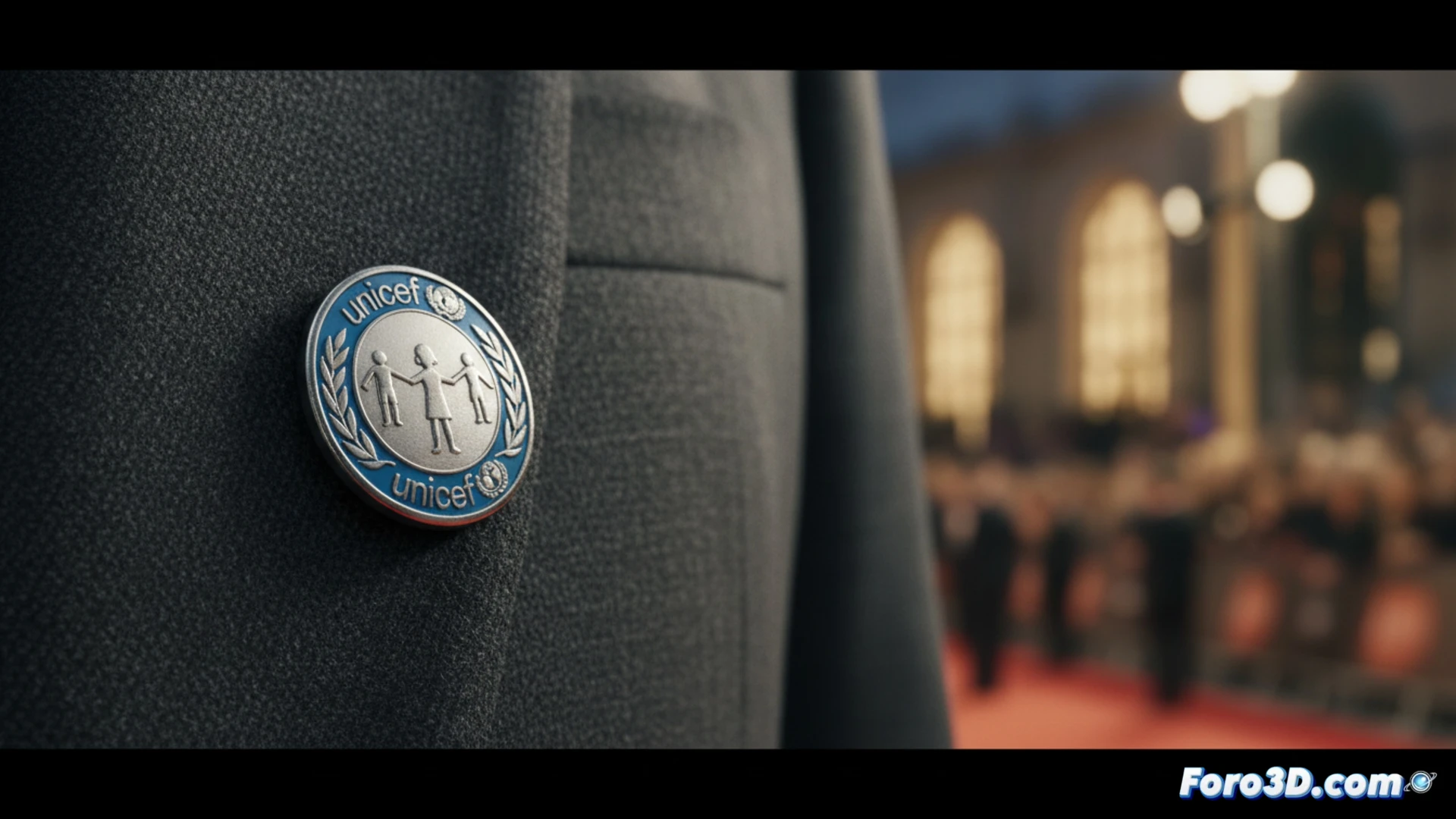 Un cantante en alfombra roja con chapa de UNICEF, mientras detrás se proyectan imágenes 3D de niños y una bandera palestina digital.